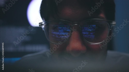 Intense Focus of Software Engineer Reflecting Blue Code in Lens