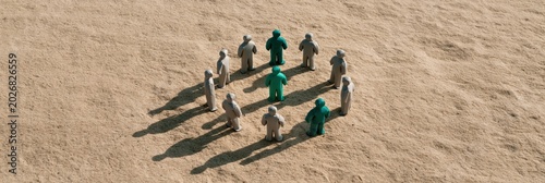 Aerial view of wooden peg people arranged in a circle with green leaders for teamwork and inclusion background for business banner and social concept