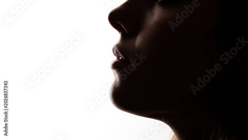 Close-up profile silhouette of a person's face with lips slightly parted, evoking a sense of contemplation or anticipation
