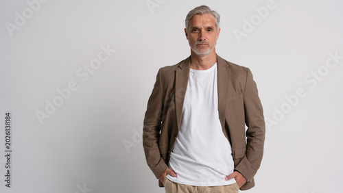 Cuadro en lienzo Serious middle-aged man posing in front of a grey background with copy space
