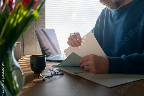 Male entrepreneur reviewing documents while working from home