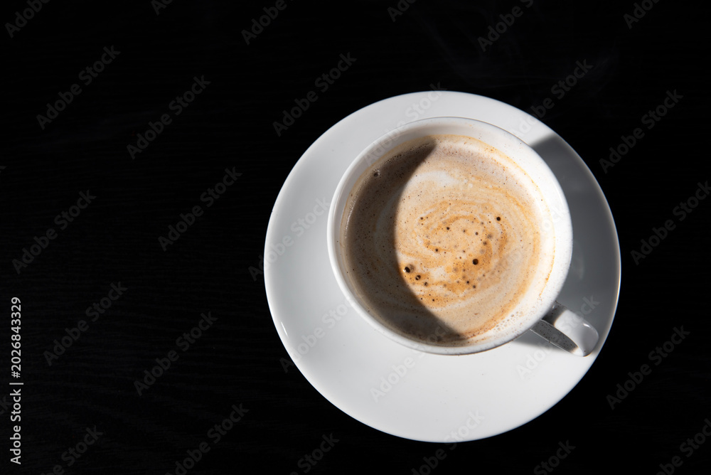 Fototapeta premium Premium dark roast arabica coffee beans with cozy cup of warm steaming coffee and sugar on dark background with copy space