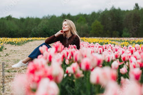 A young woman in a field of tulips. 
