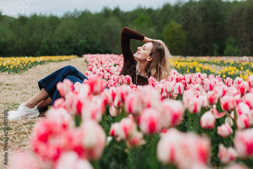A young woman in a field of tulips. 