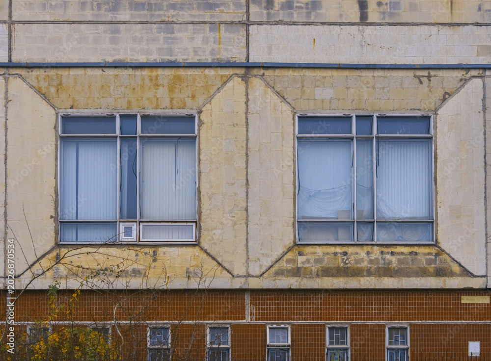 Obraz premium Suburban window with curtains. Close shot of residential window with aged details and soft lighting