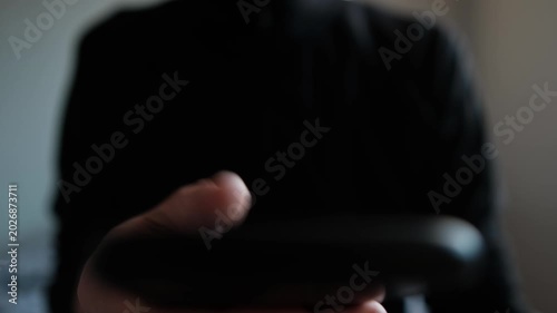 Closeup hands holding phone daytime scroll feed, soft natural light silhouette torso, repeated thumb swipes, distracted routine and subtle tension, habitual