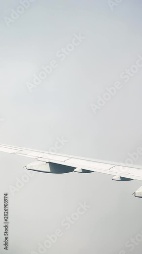 Wing view, flight on an aircraft, view of a endless clouds and a bright sky, tourism business.