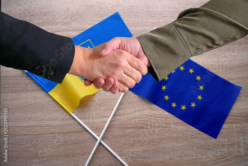 Handshake Between European Union and Ukraine Flags. European Union and Ukraine Partnership
