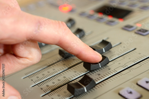 Foto Close-up of sound engineer hand adjusting fader on audio mixing console