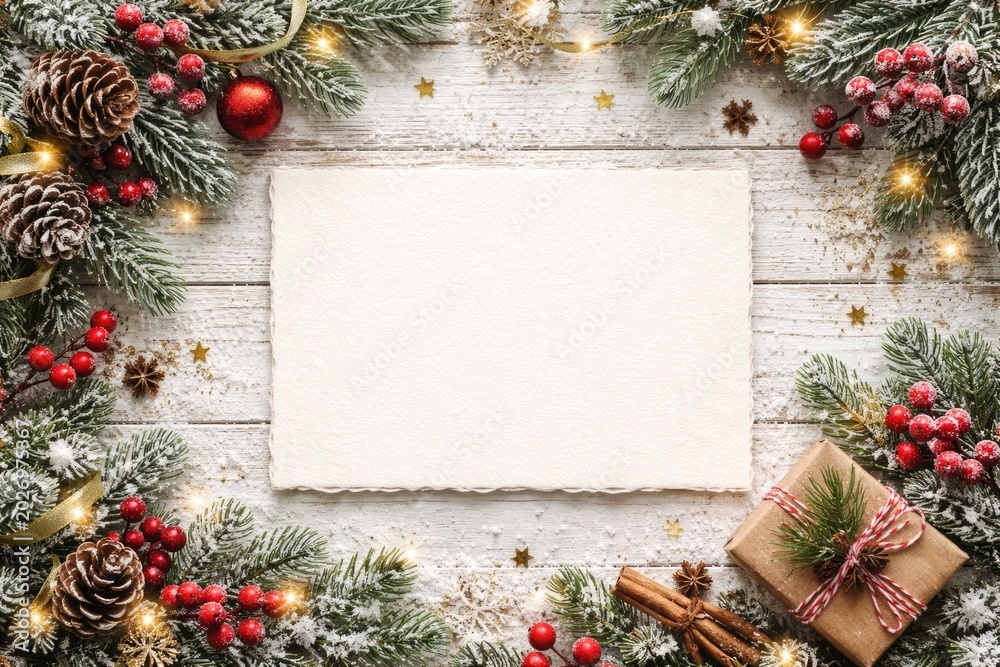 Fototapeta premium Winter holiday greeting card adorned on white wood backdrop with space for message from top view