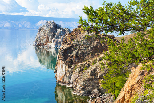 Siberian Lake Baikal on a summer sunny day. View of the rocky shores of Olkhon Island and the natural monument Shamanka Rock, nature reserve, Pribaikalsky natural Park. Beautiful seascape