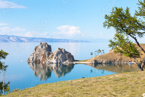 Baikal Lake on a sunny summer day. Tourists love to visit Olkhon Island, relax on the shore, admire the beautiful scenery near Shamanka Rock, and go boating. A beautiful, calm summer seascape