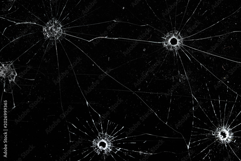 Fototapeta premium Bullet holes on black glass, overlay design background