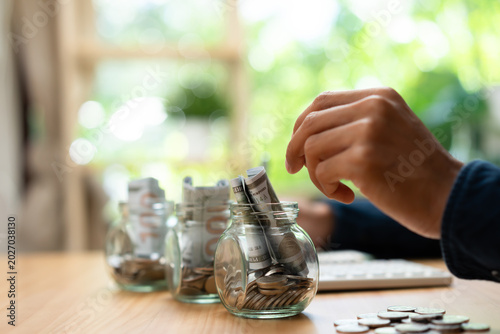 Bild auf Leinwand Retirement savings and financial planning concept with money jar, coins, currency, and bank fund investment, representing long term wealth management and future financial security