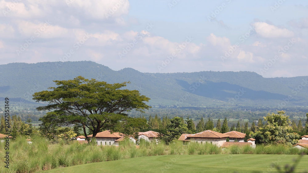Fototapeta premium Panoramic View of a Rural Village Nestled Against Lush Green Mountains