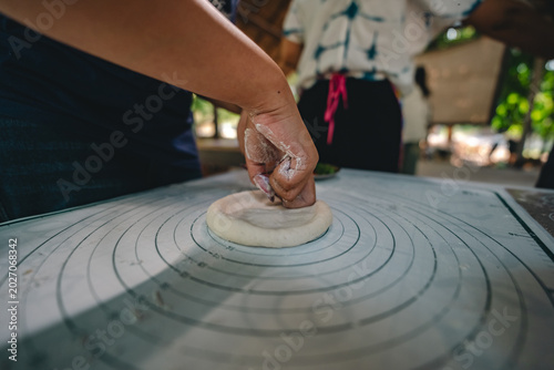 Schilderij op canvas Italian pizza cooking process, dough knead hand flour round pastry table outdoor
