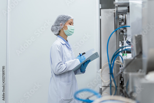 Принти на полотні Medical technician reviewing data near factory machinery