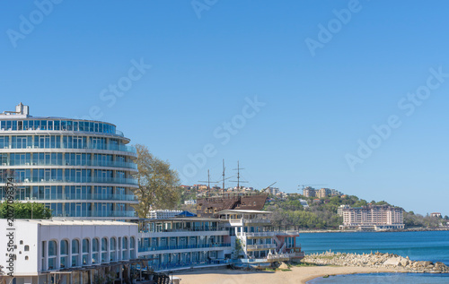 Canvas-taulu Coastal resort featuring modern glass hotels and a unique pirate ship-style buil
