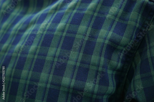 Cotton flannel fabric background with a repeating checkered pattern and a combination of blue and green colors
