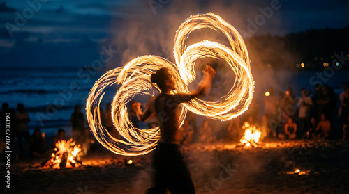 A person performs fire dancing on a beach at night with a crowd watching flames.