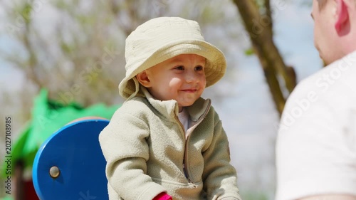 Child enjoys playtime at park with father on a sunny day