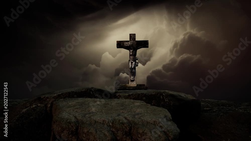 Dark dramatic scene of a Christian crucifix standing on rocks with stormy clouds and heavenly light beams. Ideal for Good Friday, crucifixion, Easter, and spiritual content.