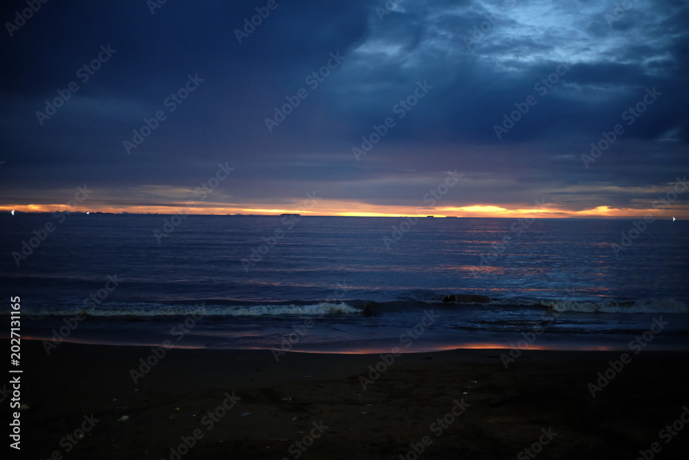 Fototapeta premium Coastal Sunset Under Heavy Clouds