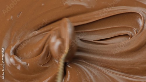 Stirring process of smooth chocolate spread. Macro abstract view.