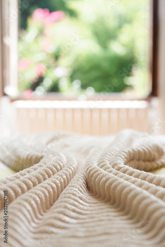 Lit avec couverture texturée dans chambre lumineuse – ambiance cocooning et détente