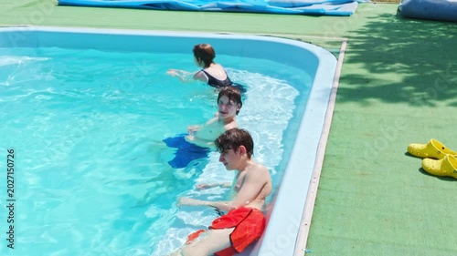 Boys swimming and playing in the pool on a sunny day