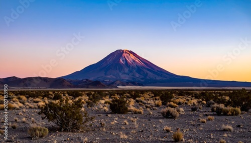 Desert landscape with a prominent mountain at sunset, clear sky