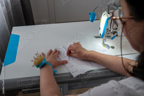 Foto Woman working with textile fabric and sewing pins during dressmaking process in atelier