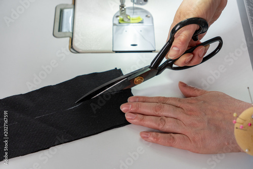 Фотография Macro closeup of fabric cutting during dressmaking and sewing process