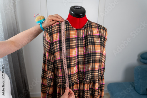 Photography Woman taking body measurements on professional tailor mannequin during dressmaking and sewing process in atelier