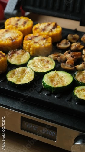 Cooking Corn, Zucchini, and Mushrooms Together on Home Grill Plate.