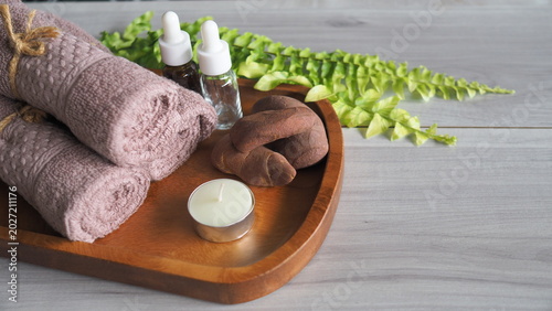 Canvas Print Spa wellness composition with rolled towels, essential oil dropper bottles, massage stones and candle on wooden tray