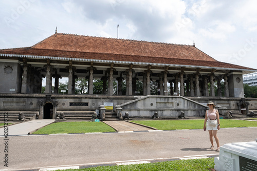 Female tourist walking past the grand Independence Memorial Hall pavilion in Colombo, Sri Lanka.