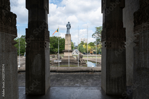 View of the independence monument statue framed by stone pillars of the Memorial Hall in Colombo, Sri Lanka.