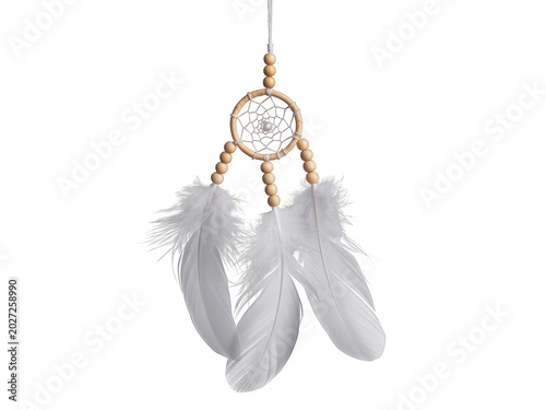 A dreamcatcher with white feathers hangs from a string.