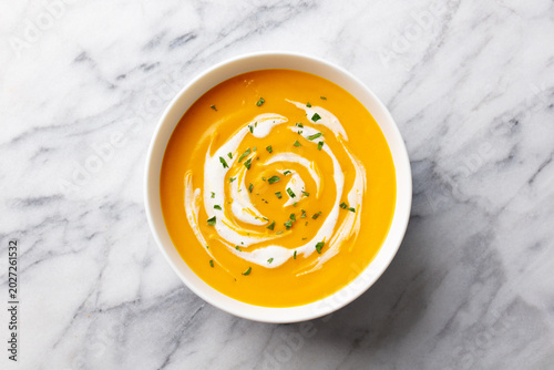 Pumpkin, butternut squash soup in bowl. White marble background. Close up. Top view.