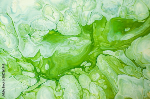 Green abstract design with smooth lines and curves made from paint on a canvas