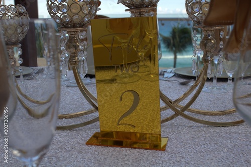 Photography Elegant oceanfront wedding reception table setting with gold accents