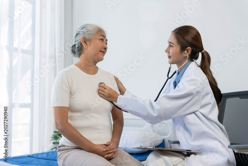 Doctor examining an elderly woman with a stethoscope, providing healthcare, medical checkup, and elder care in a hospital