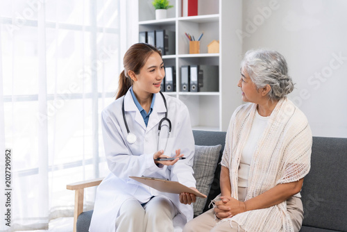 Female doctor talking with senior woman during a home medical consultation, providing professional healthcare and support