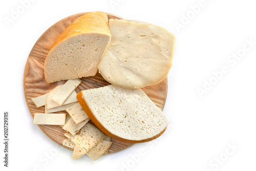 Traditional Smoked Hutsul craft cheese budz with slices on round wooden board, top view