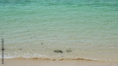 Serene Beach Scene with Clear Turquoise Water and Sandy Shore, Showcasing Tranquility and Relaxation as Gentle Waves Lap at Ocean