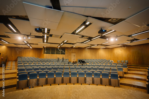 Quadro em tela Modern auditorium interior with tiered seating, wooden paneling, and advanced li