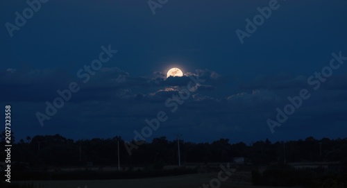 A full moon rising above a ...