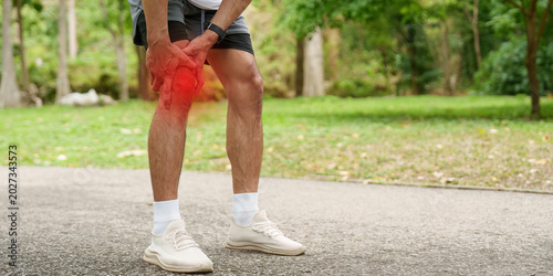 Fotografía Asian man with knee pain during outdoor sport activity in park