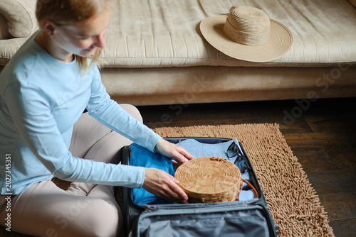 Photos Close up woman packing clothing for summer vacation